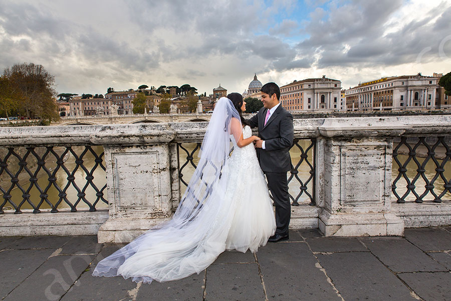 Castel Ponte Sant'Angelo. Full view of bride and groom in their matrimony attire.