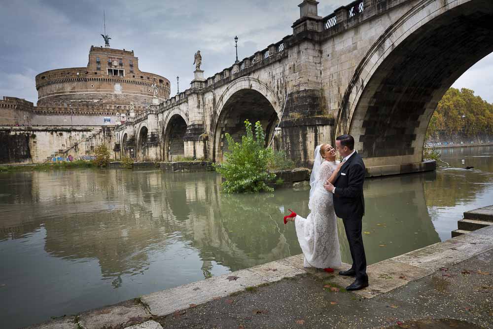 Bride and groom down underneath the bridge of Saint Angel Castle in Rome.