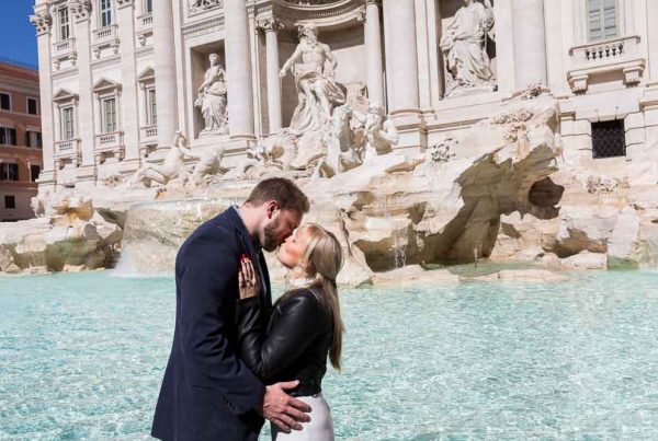 Kissing at the Trevi fountain during an engagement photo shoot in Rome