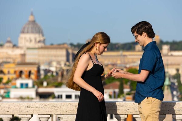 Putting the engagement ring on the finger after a surprise marriage proposal in Rome Italy