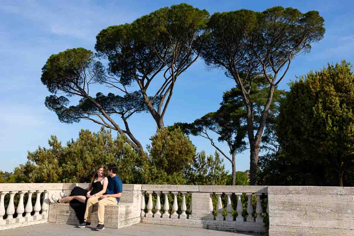 Sitting down just engaged in Rome under Mediterranean pine trees that characterize the city of Rome Italy