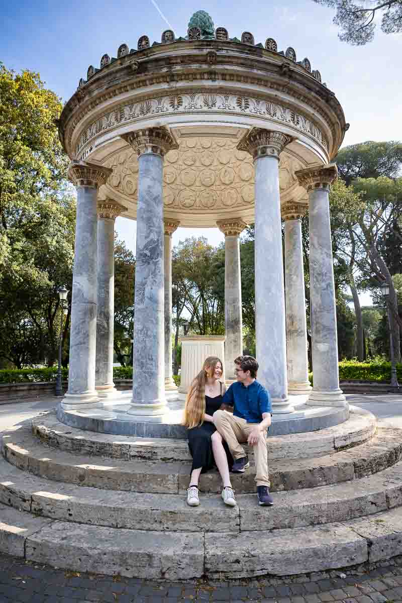 Couple sitting down on the steps of the Diana temple in the Borghese park