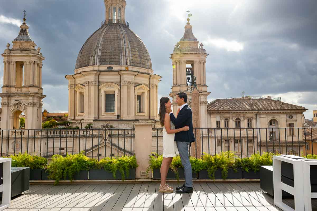 Couple standing on a terrace overlooking a 17th century baroque church 