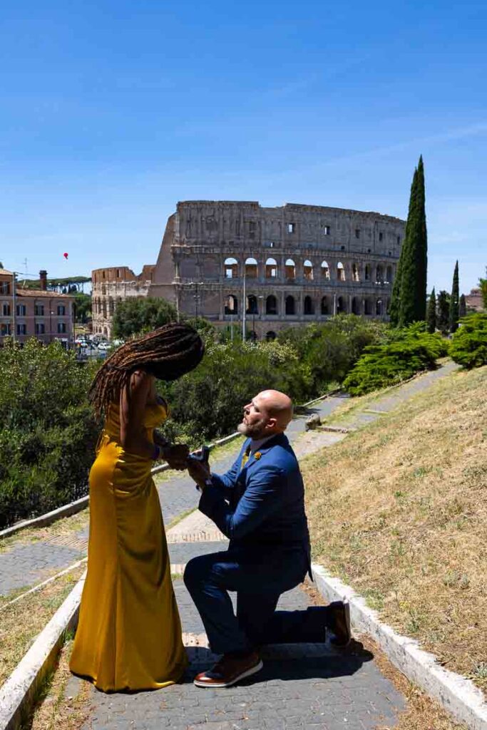 Colosseum Rome Proposal photography capturing the proposing moment as he kneels down to ask the big question