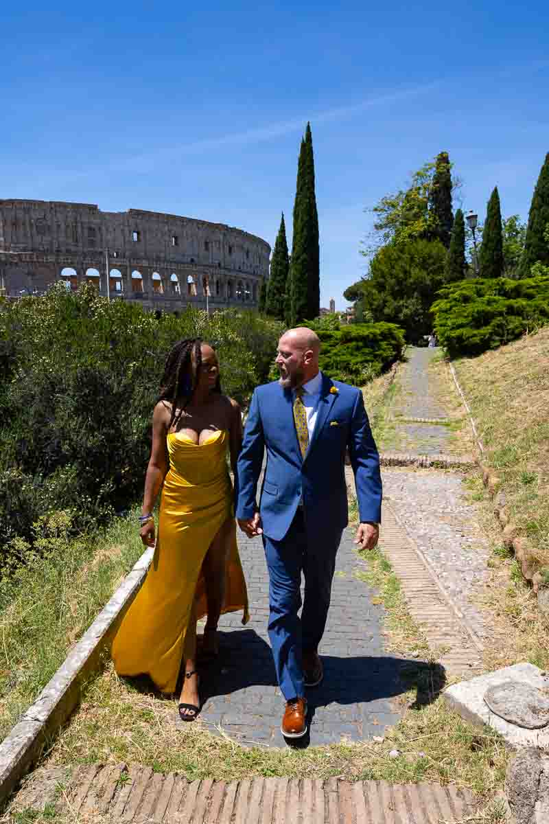 Walking together in Rome holding hands with the Colosseum in the background 