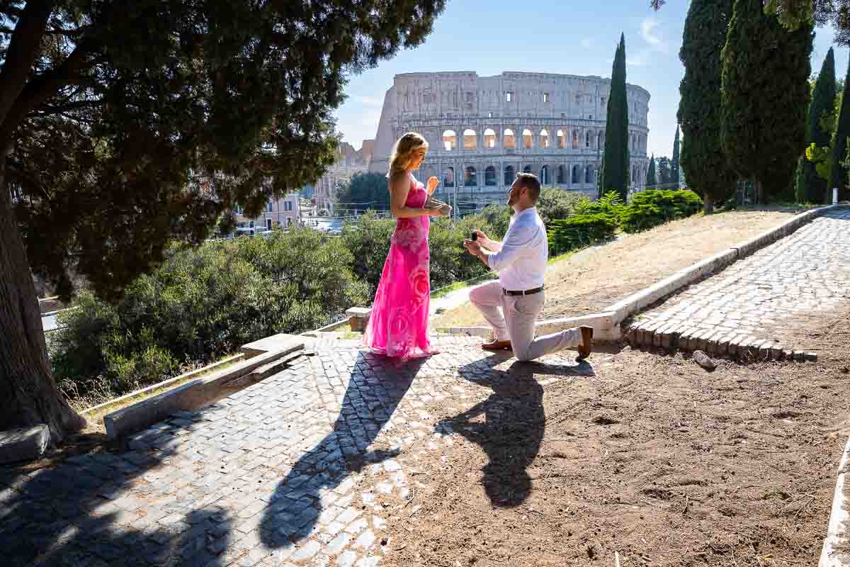 Knee down Rome Coliseum proposal candidly photographed from a park 