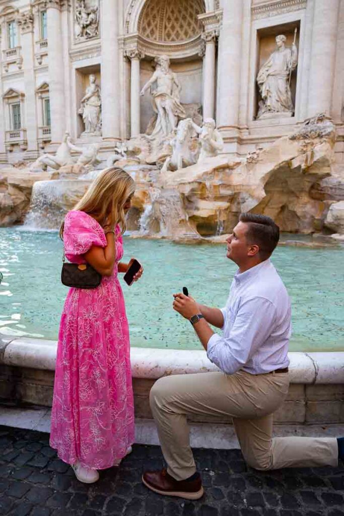 Kneeling down for a proposal at the Trevi fountain in Rome Italy