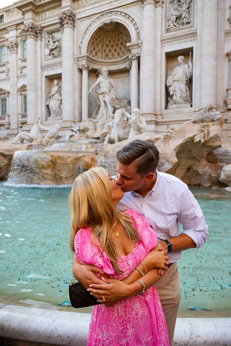 Couple kissing in front of the Trevi fountain during an engagement photo shoot in Rome Italy