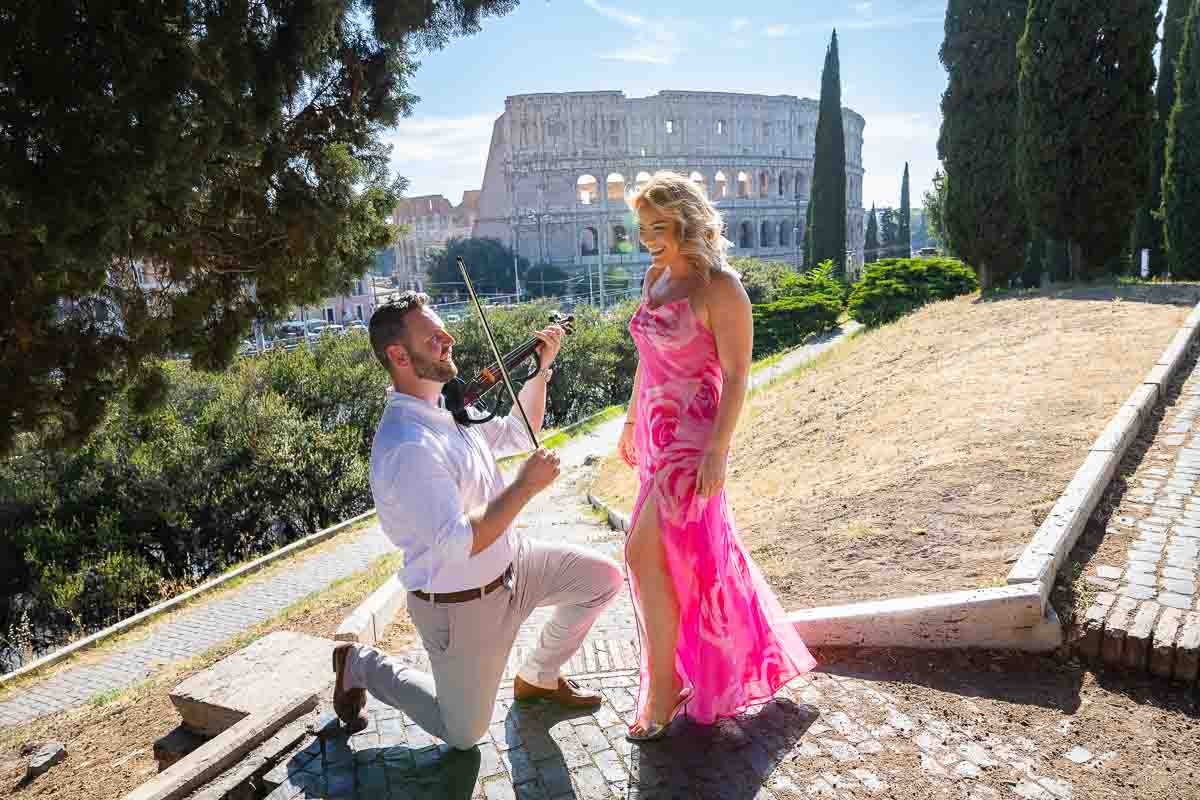 Playing violin music during a Rome Coliseum Proposal in front of one of the most iconic symbols 