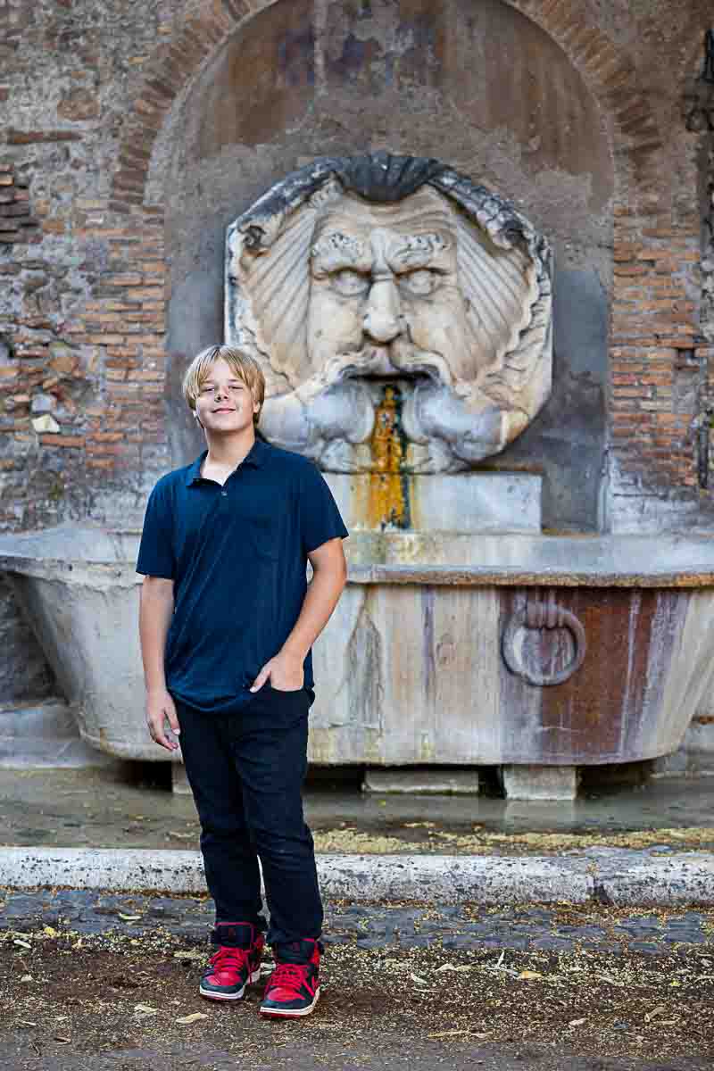 Standing portrait in front of a unique water fountain found at the entrance of the orange garden 