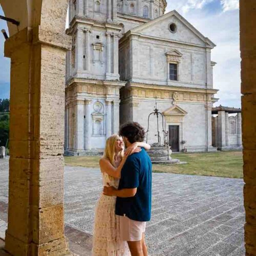 Posing together in front of the church of San Biagio in Tuscany Italy at sunset