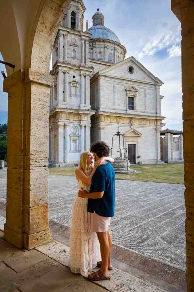 Posing together in front of the church of San Biagio in Tuscany Italy at sunset