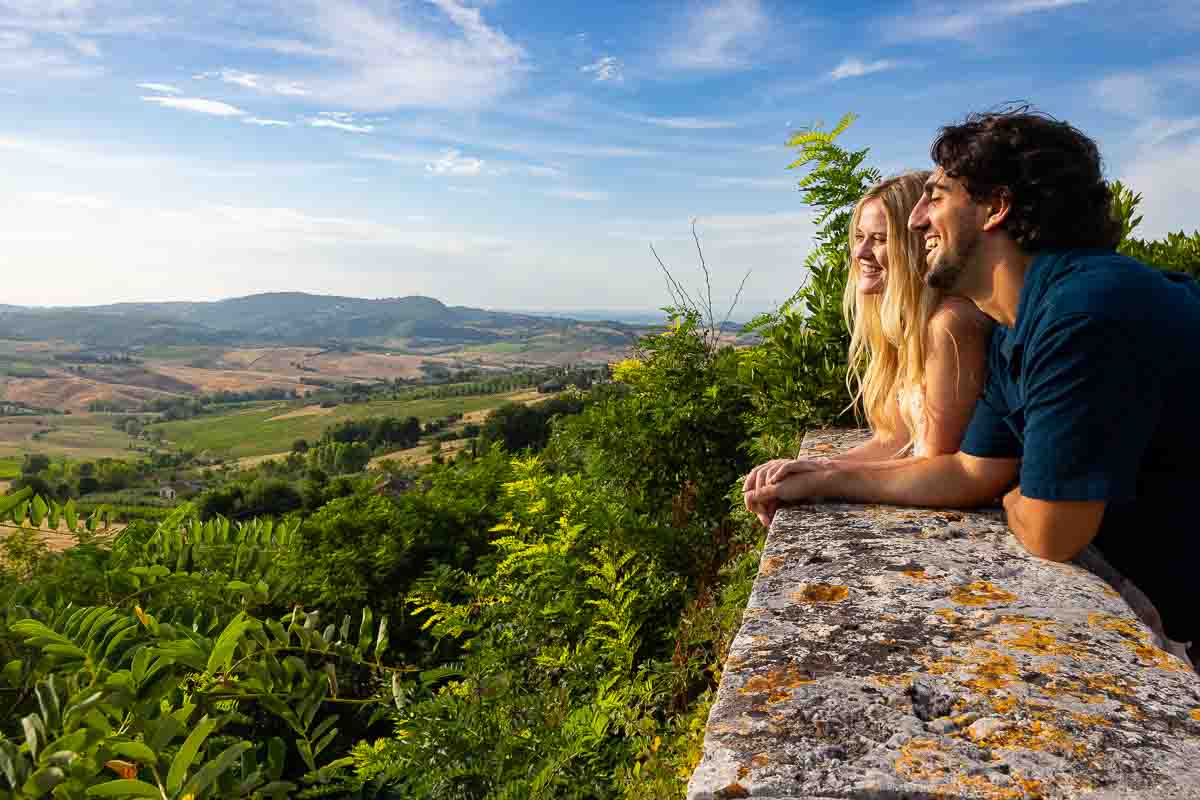 Couple admiring the Tuscan countryside at sunset during a couple photoshoot 