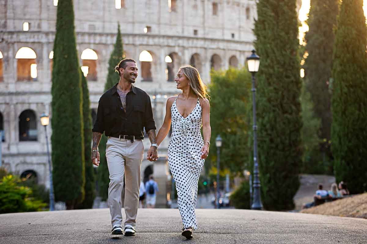 Walking hand in hand in park with a unique view of the Colosseum 