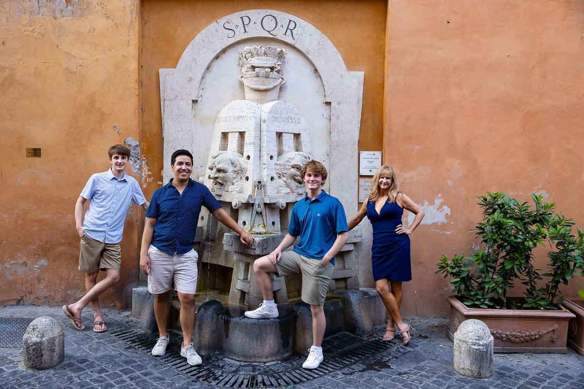 Family photographer taking pictures by a water fountain