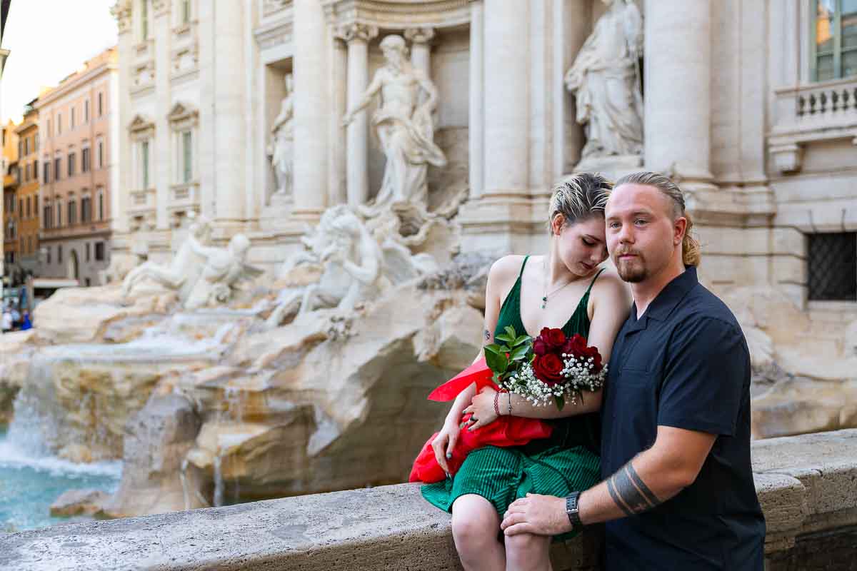 Just engaged posing on the top of the Trevi fountain after a beautiful and romantic Surprise Wedding Proposal 