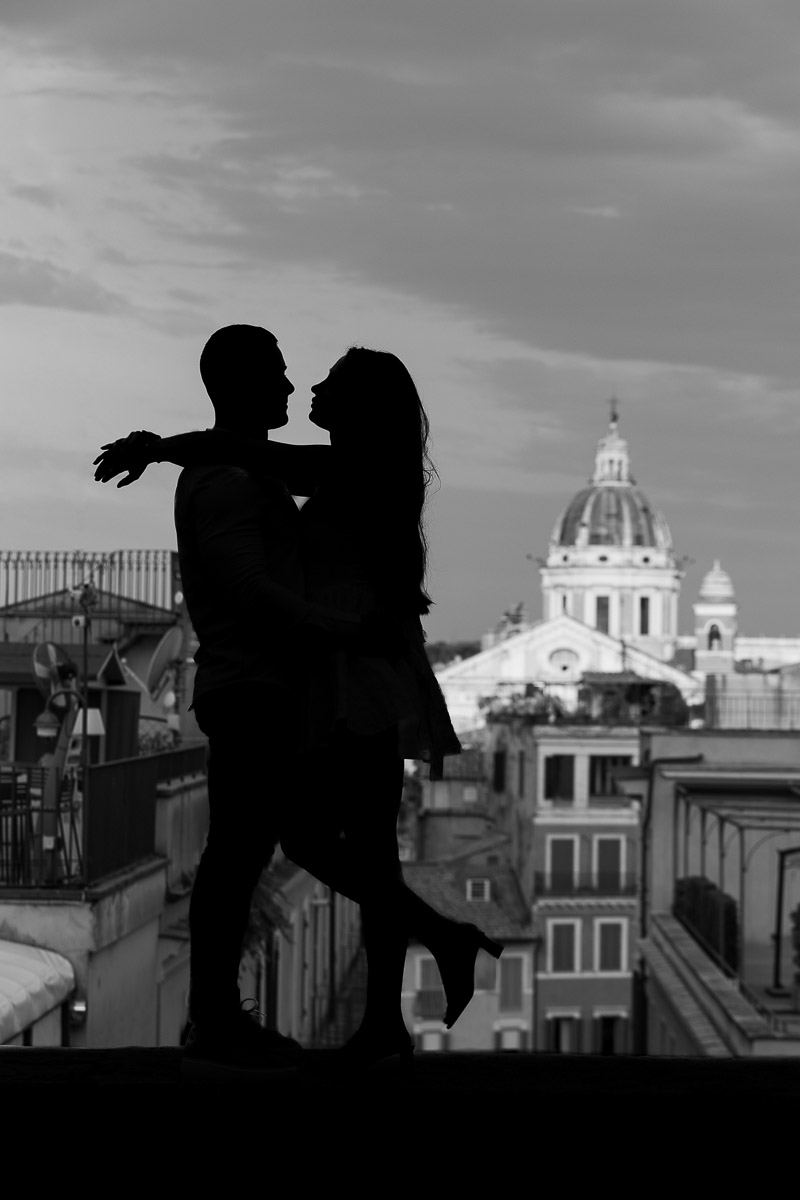 Black and white silhouette image of a couple posing in front of the Rome cityscape 