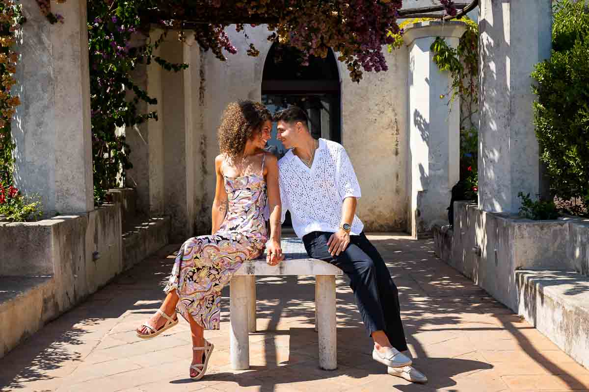 Sitting down next to one another during a photographer session in Ravello after proposing in Villa Rufolo in Italy