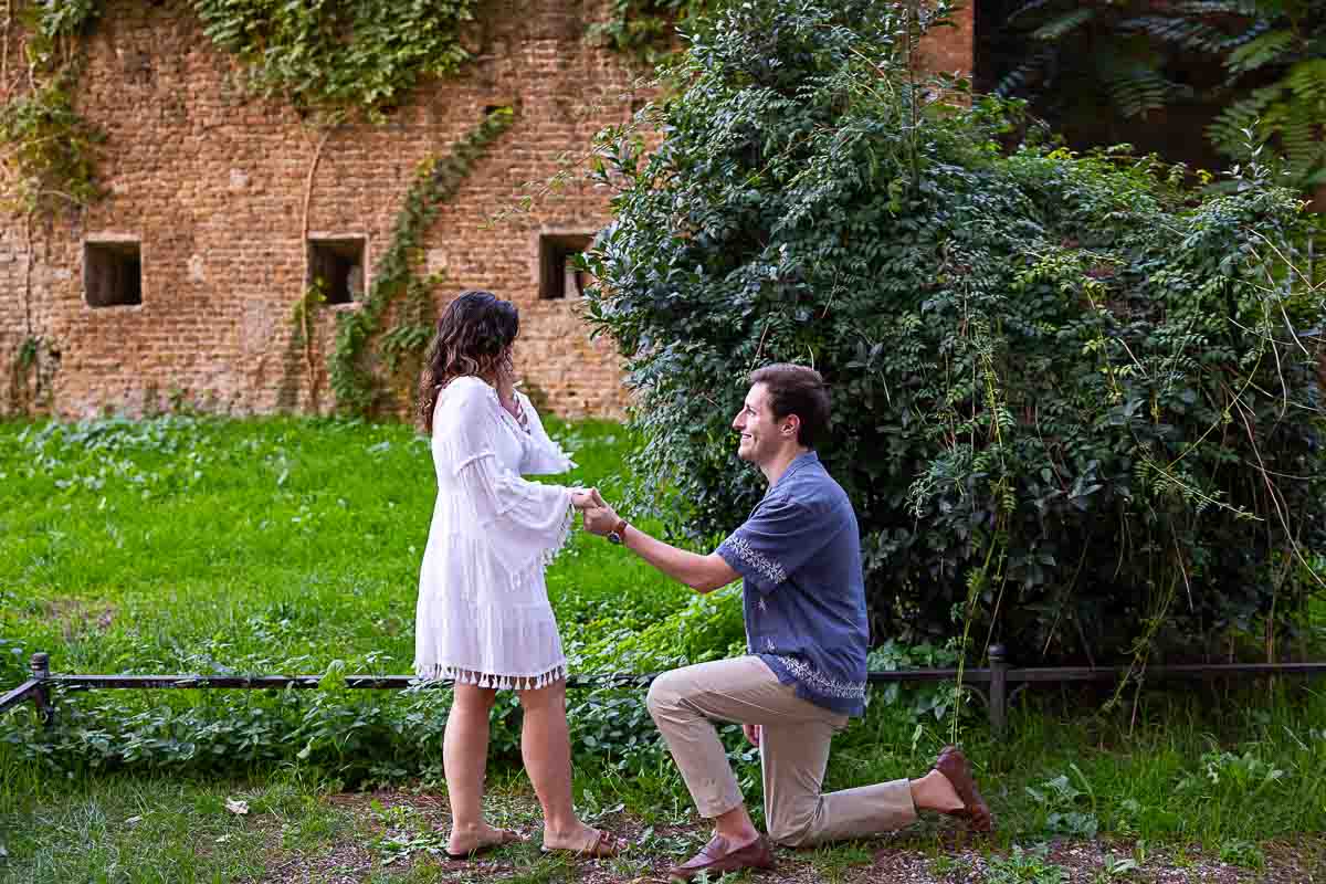 Kneeling down and proposing marriage in the park of Giardino degli Aranci in Rome Italy. Orange Garden Sunset Proposal