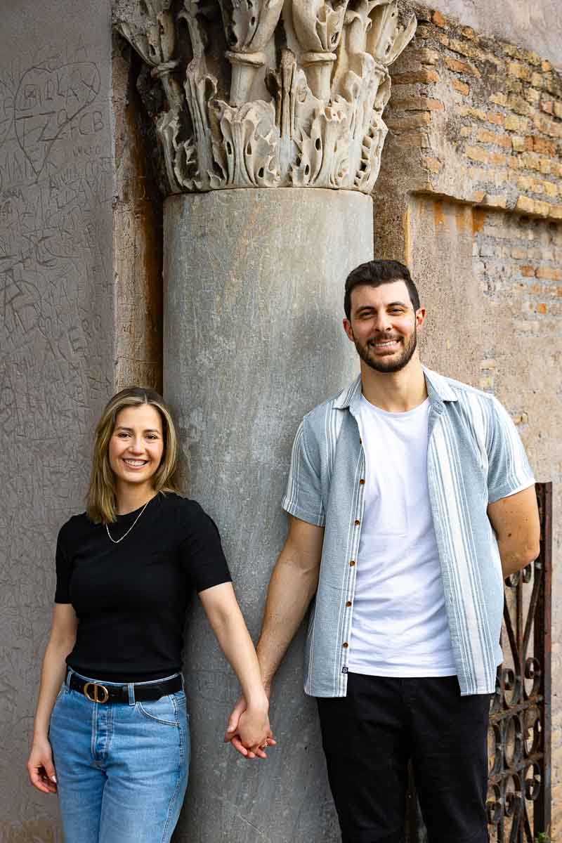 Couple portrait holding hand in front of a roman column 