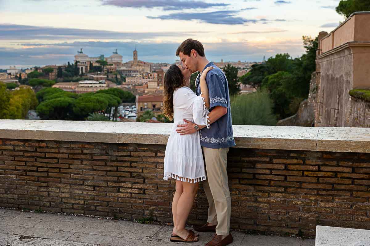 Kissing before the roman skyline after a romantic surprise wedding proposal 