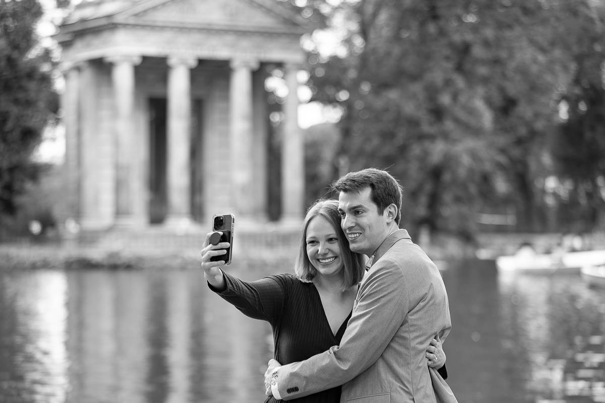 Taking a selfie picture at lakeside in bw during the engagement photo session after a romantic surprise wedding proposal