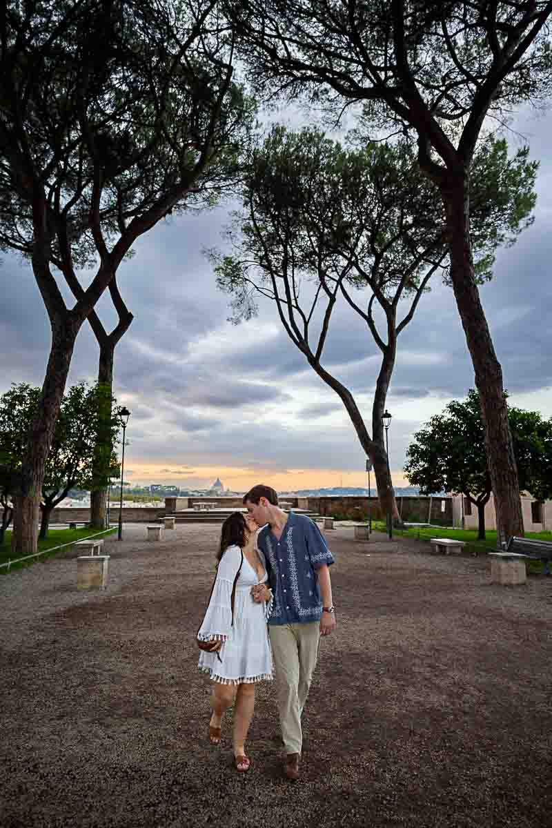 Walking while kissing underneath the Mediterranean pine trees above the park 