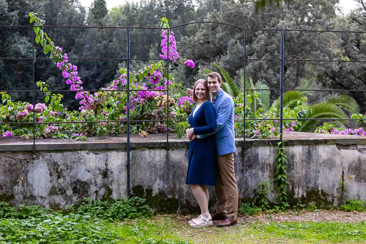 Standing posed by the Borghese gardens in front of a bougainvillea plant with fuchsia flowers