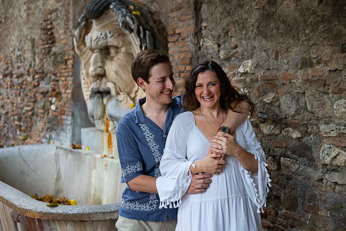 Smiling and happy portrait while shooting in front of the water fountain found at the entrance of Orange garden park in Rome 