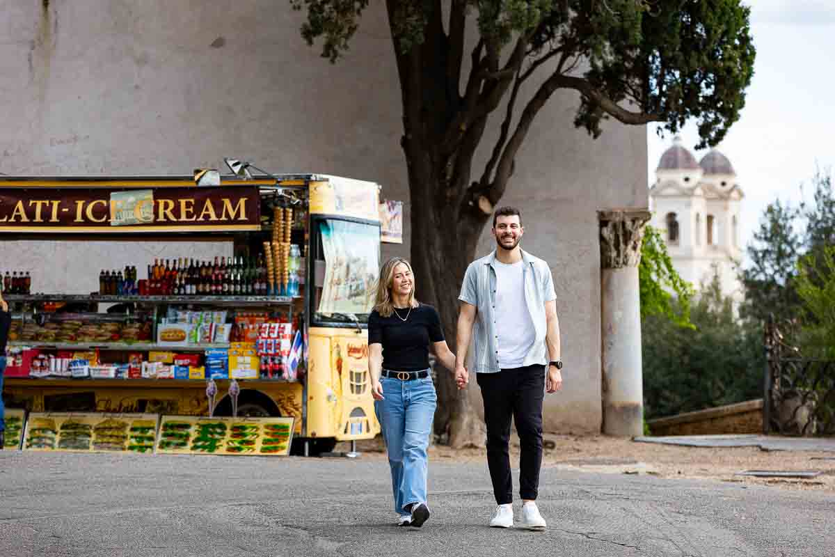 Walking together holding hands in front of a typical beverage truck 