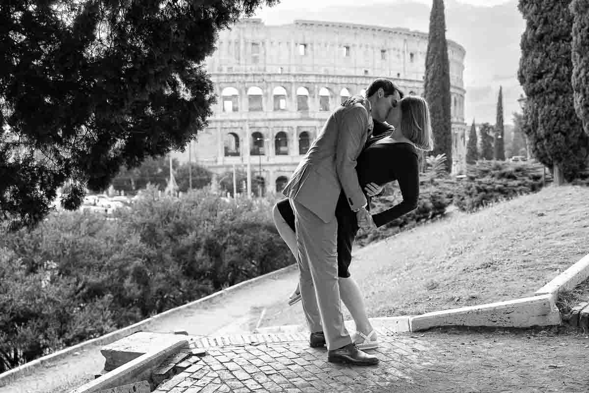 Black and white posed photo in front of Rome's Colosseum