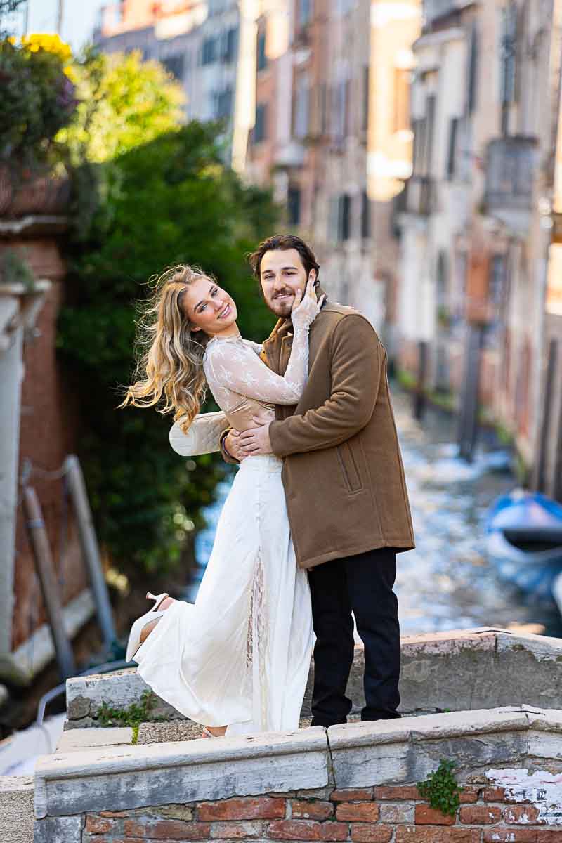 Couple posing during a photoshoot in Venice Italy after a surprise marriage proposal