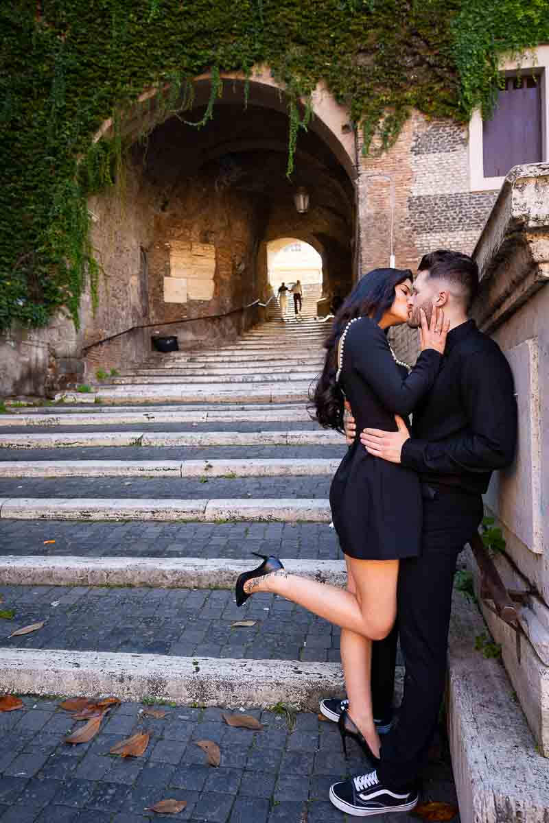 Couple kissing at the bottom of the Borgia staircase photography session in Rome Italy