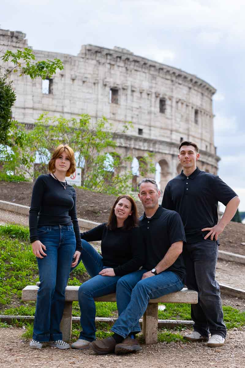 Sitting down family portrait picture before the Roman Colosseum . Rome, Italy