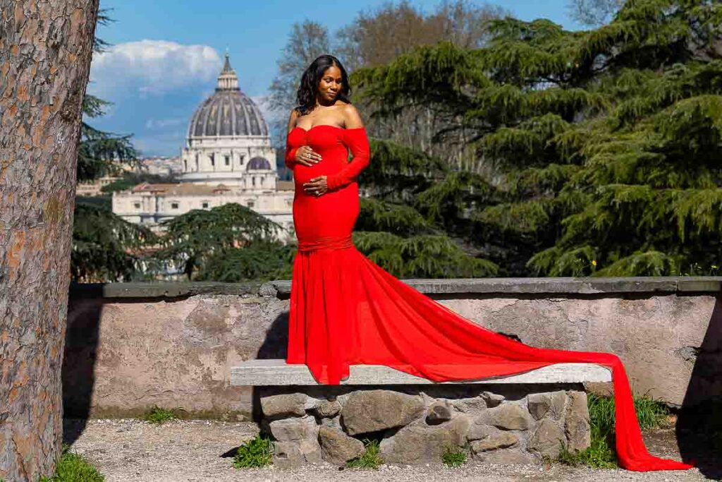 Standing alone as a solo pregnancy portrait photo in Rome by Saint Peter's cathedral in the far distance