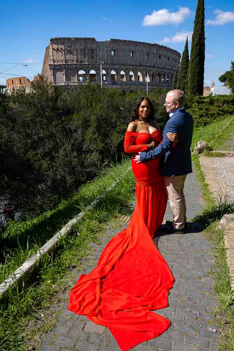 Colosseum pictures taken during a maternity photoshoot in Rome Italy using a bright red dress 