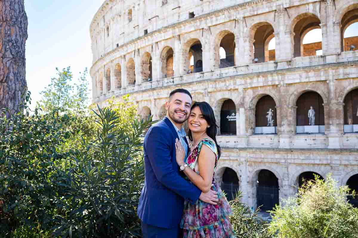 Posed portrait of a couple standing at the Colosseum. Surprise Proposal Photography and Video in Italy while on an engagement photography session 